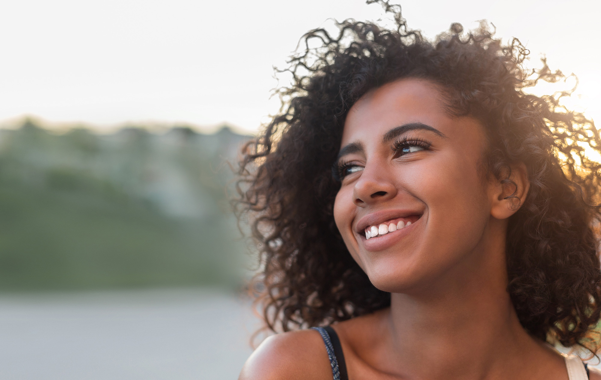 Woman smiling in sunlight — somatic healing at Newmarket Therapy Centre